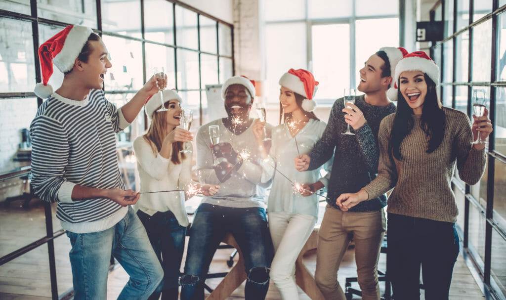 Group of young business people celebrating in Santa hats.